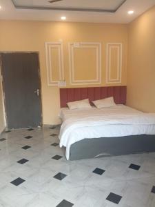 a bedroom with two beds and a tiled floor at Riyank Farms in Patna