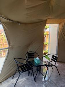 two chairs and a table in front of a tent at Sangkuriang 1 - Private Dome in Bandung