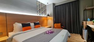 a bedroom with a large bed with purple flowers on it at Extreme Boutique Hotel in Kluang