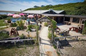 a garden center with tables and umbrellas in front of a building at Golden Sands Escape Weymouth Entire House in Wyke Regis
