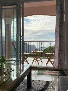 a balcony with a table and a view of the ocean at Green Discovery B&B Tamarind Falls 7 Cascades in Henrietta