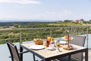 a table with food on a balcony with a view at Weinhof Reichmann in Sankt Peter am Ottersbach