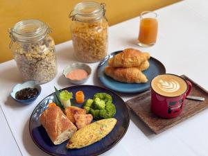 a table with two plates of food and jars of food at Emerald Angkor Siem Reap in Siem Reap