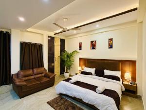 a bedroom with a large bed and a leather couch at Hotel Prime Stay in Noida