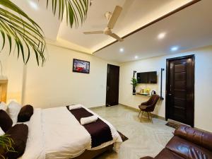 a bedroom with a bed and a couch and a tv at Hotel Prime Stay in Noida