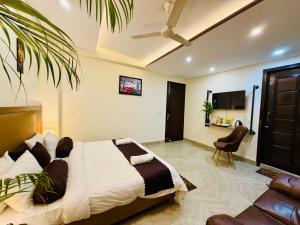 a bedroom with a bed and a chair and a tv at Hotel Prime Stay in Noida
