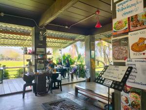 a restaurant with a table and people sitting at tables at Hamenameng in Ban Na Meng (1)