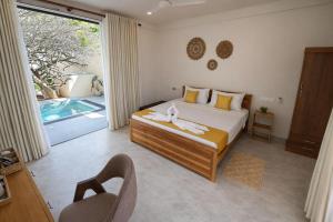 a bedroom with a bed and a large window at Gatch Villa in Unawatuna