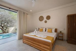 a bedroom with a bed and a large window at Gatch Villa in Unawatuna