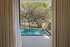a view of a swimming pool through a window at Gatch Villa in Unawatuna
