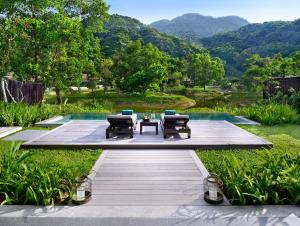 a patio with a table and chairs next to a pool at Banyan Tree Lang Co in Hue