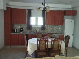 a kitchen with a table and chairs and a window at Spiti Lou in Nótos