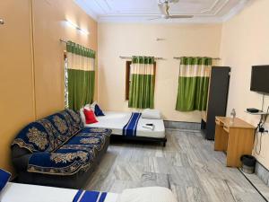 a room with two beds and a couch at Ozzy Rooms in Kolkata