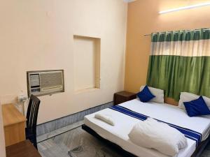 a small room with a bed with a window and a radiator at Ozzy Rooms in Kolkata +1 photo