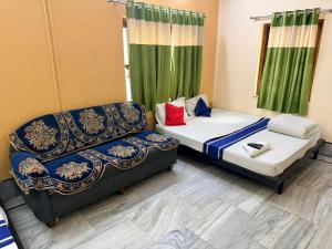 two beds in a room with green curtains at Ozzy Rooms in Kolkata