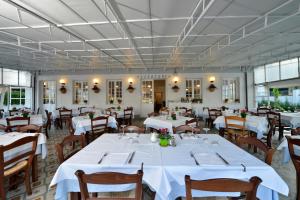 a dining room with white tables and chairs at Hotel Garden Bocca di Magra in Bocca di Magra