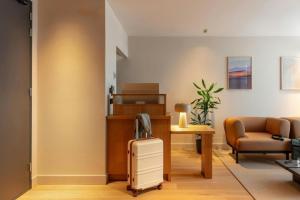 a living room with a suitcase and a chair at Hotel Middelland Rotterdam in Rotterdam