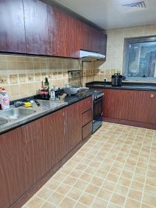 a kitchen with wooden cabinets and a stove top oven at King bed sea view in Sharjah