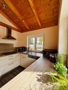 a kitchen with white cabinets and a wooden ceiling at Ferienhaus Fichtelwichtel in Mehlmeisel