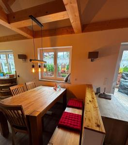 a dining room with a wooden table and a bench at Ferienhaus Fichtelwichtel in Mehlmeisel +8 photos