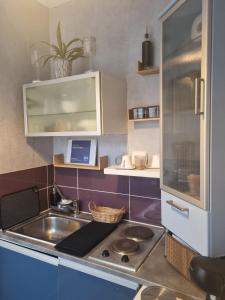 a small kitchen with a sink and a stove at Villa Seven Petit Studio coin kitchenette in Dunkerque