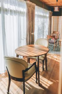 a table and chairs in a room with windows at keganiya 一棟貸し北九州空港近くの和風宿 in Yukuhashi