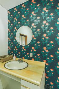a bathroom with a sink with a flowery wallpaper at keganiya 一棟貸し北九州空港近くの和風宿 in Yukuhashi