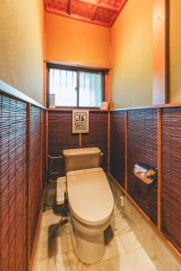 a bathroom with a toilet in a room with wooden walls at keganiya 一棟貸し北九州空港近くの和風宿 in Yukuhashi