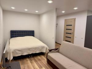 a bedroom with a bed and a couch at Studio Ap in Visaginas