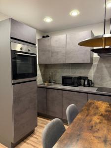 a kitchen with a wooden table and a kitchenasteryasteryasteryasteryasteryasteryastery at Studio Ap in Visaginas