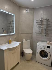 a bathroom with a toilet and a washing machine at Studio Ap in Visaginas +19 photos