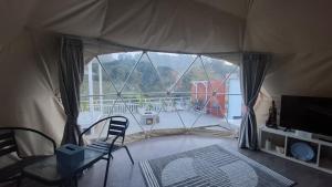a room with a tent with a chair and a television at Sangkuriang 2 - Private Dome in Bandung