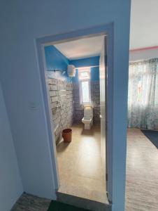 a bathroom with a white toilet and a window at Mayal Lyang Lachung in Mangan