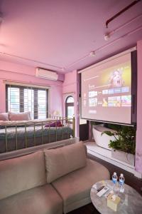 a living room with a couch and a large screen at Trên Mây HST - 181 Trần Phú in Hanoi