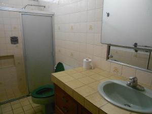 a bathroom with a sink and a toilet and a mirror at Hostal Cumbres del Volcán Escalón in San Salvador