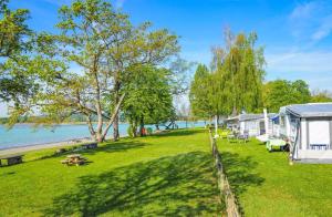 a large yard with a tent and the water at Camping Willam in Reichenau