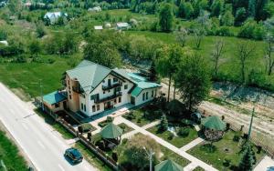an aerial view of a large house with a green roof at Pensiunea Maria in Agapia