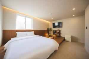 a bedroom with a large white bed and a window at DadamHotel in Suwon