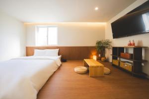 a bedroom with a bed and a flat screen tv at DadamHotel in Suwon