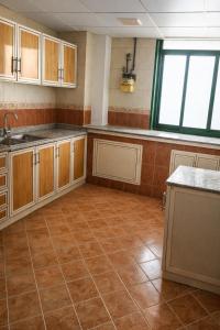 a kitchen with wooden cabinets and a tile floor at ALEX Hostel - Bed in a shared room - C504 in Sharjah