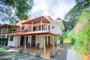 a house with a balcony and tables and chairs at The Lux Villa in Habaraduwa Central