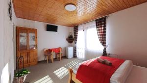 a bedroom with a bed with a red blanket at Apartmán Otília in Ždiar