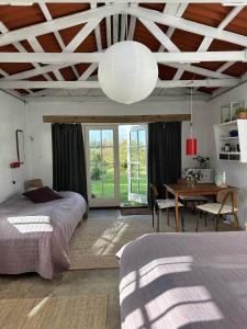 a bedroom with a bed and a dining room with a table at Camønogaarden B&B, darksky cabins and events in Borre