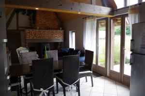 a dining room with a table and chairs and a fireplace at Ndila Cottage avec piscine exclusive in Fatouville-Grestain