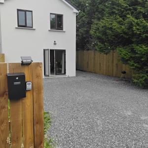 a backyard with a fence and a white house at Rossaveal Farm in Leixlip