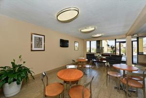 a room with tables and chairs and a living room at Super 8 by Wyndham Clarksville Northeast in Clarksville