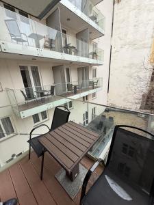 a balcony with a wooden table and chairs on a building at Carlton Hotel Buda Castle in Budapest