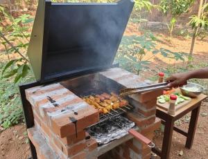 a person is cooking food on a grill at Gangadharam Tiny House 2BHK AC in Tellicherry