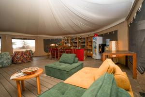 a living room with a couch and chairs and a table at Malaika Ndutu Luxury Camp in Sinoni