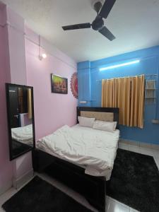 a bedroom with a bed with a mirror and blue walls at Kashiyana in Varanasi